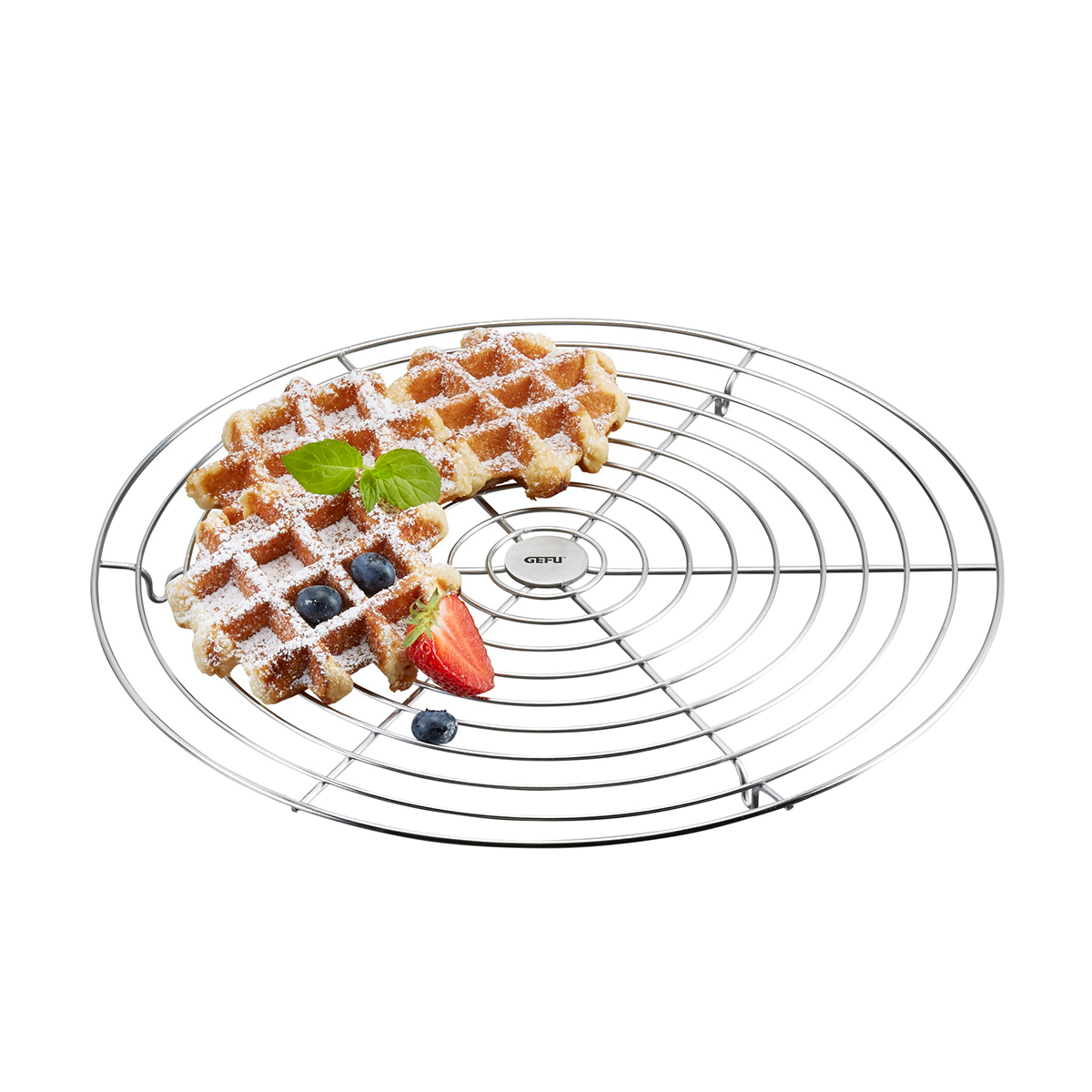 Waffeln auf einem runden Abkühlgitter mit Fruchtgarni Zwei Waffeln auf einem runden Abkühlgitter, garniert mit Puderzucker, Erdbeere, Blaubeeren und Minzblättern