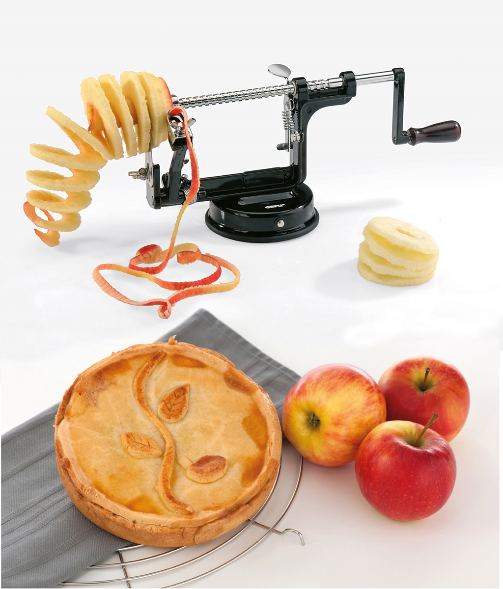 Multifunktionaler Apfelschäler mit Handkurbel, perfekt für Kuchen und Snacks Apfelschäler mit Handkurbel, geschälte Äpfel und ein Apfelkuchen auf einem Tisch