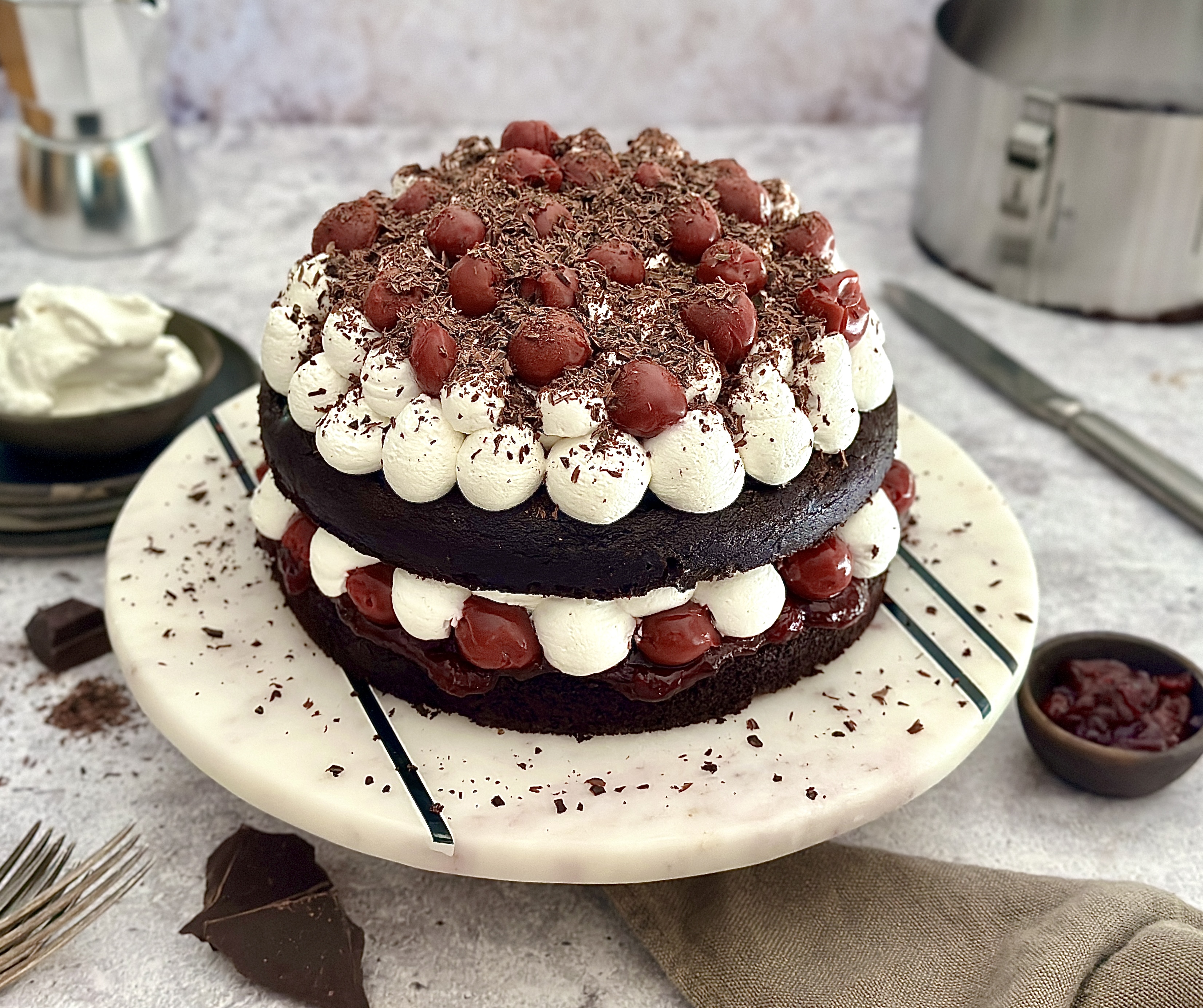 Veganer Schwarzwälder Kirsch Naked Cake Nahaufnahme einer Schwarzwälder Kirschtorte mit Sahnehäubchen, Kirschen und geriebener Schokolade auf einem Teller
