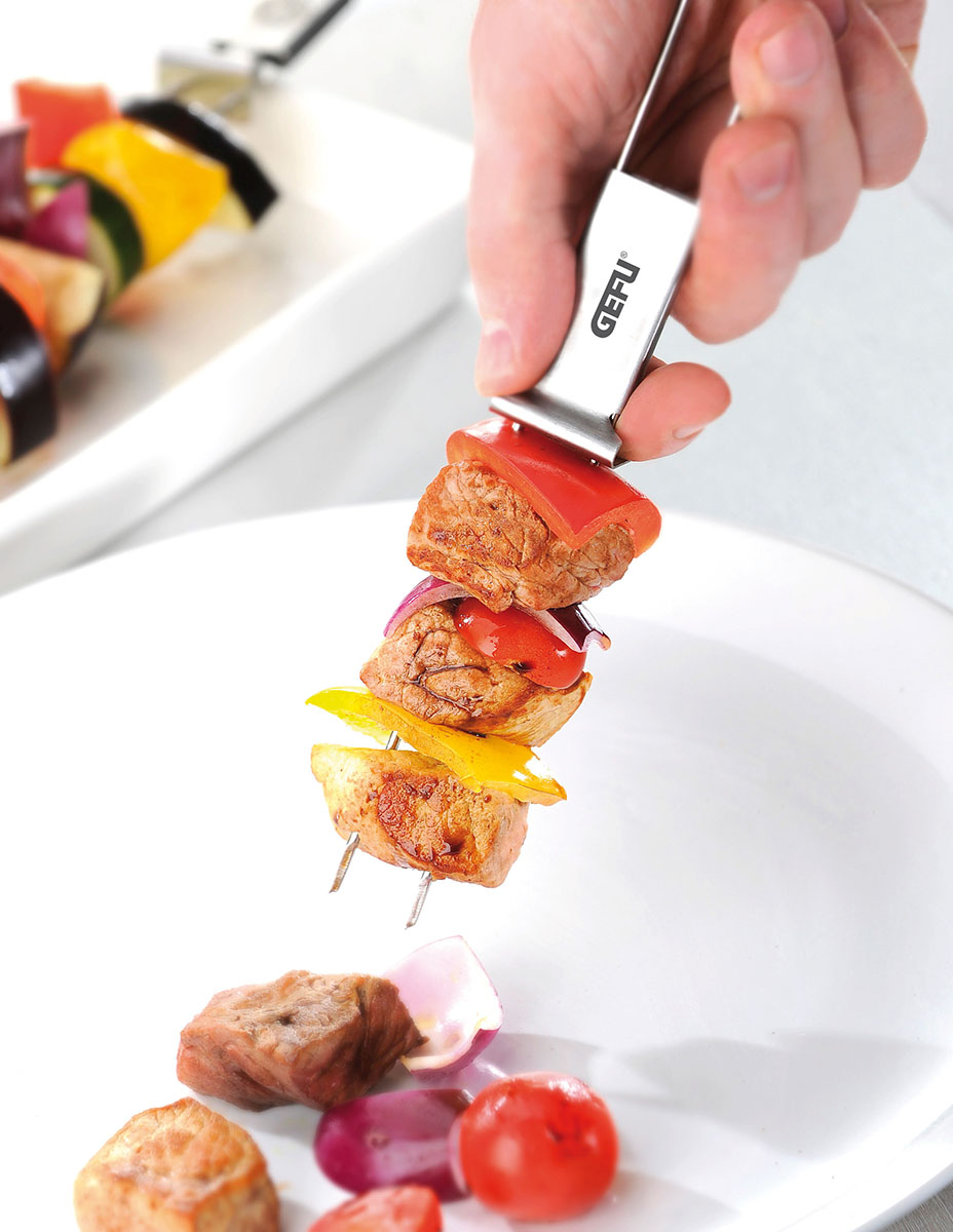 Grillspieß mit Fleisch und Gemüse auf Teller Nahaufnahme eines Grillspießes mit Fleisch und buntem Gemüse auf einem weißen Teller