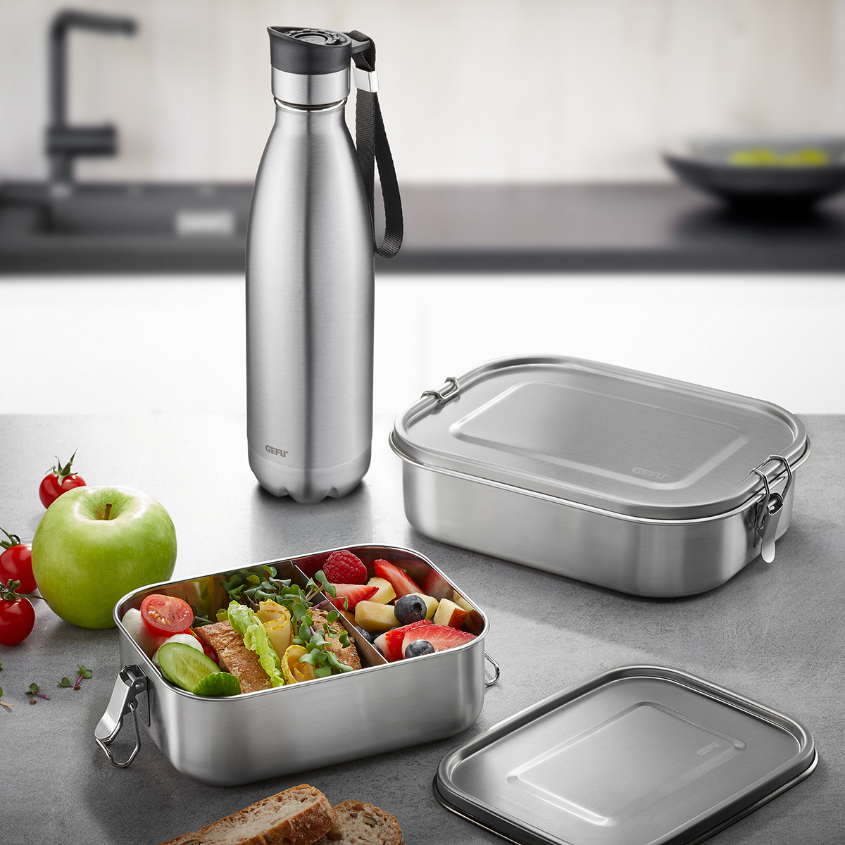 Edelstahl Lunchbox und Trinkflasche Set in moderner Küche Edles Set aus Edelstahl: Lunchbox mit frischem, gesunden Inhalt und passende Trinkflasche in einer modernen Küchenszene.