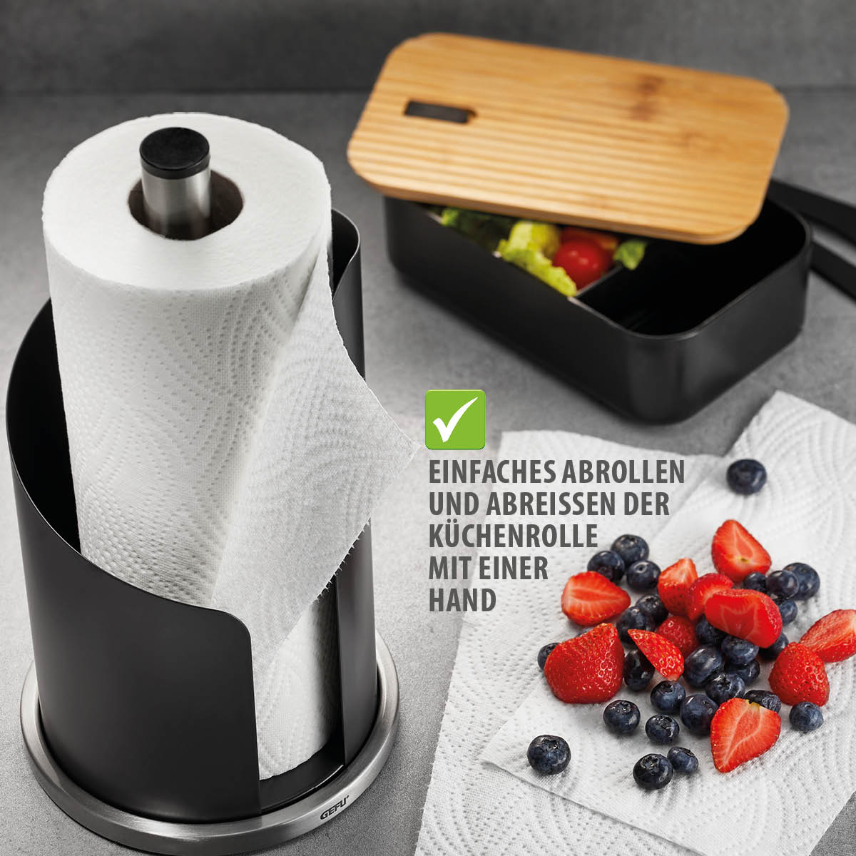 Küchenrollenhalter mit Früchten und Aufbewahrungsbox im Hintergrund