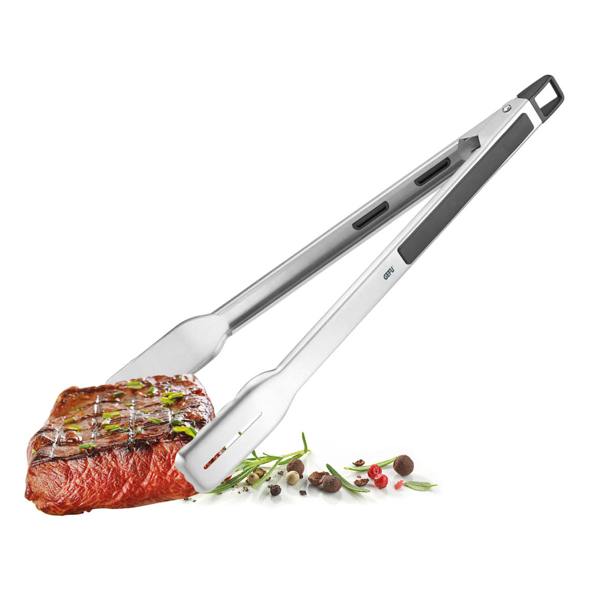 Hochwertige Grillzange aus Edelstahl mit ergonomischem Griff Grillzange aus Edelstahl hält ein saftiges Steak, umgeben von Kräutern und Pfefferkörnern