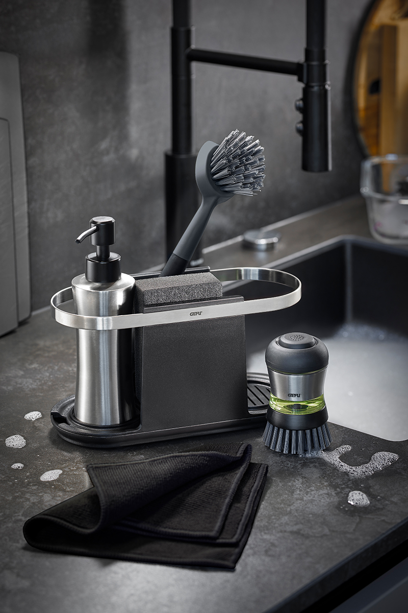Elegantes Küchenspülset mit Spender, Bürste und Schwammhalter Modernes Küchenspülset mit Spülmittelspender, Reinigungsbürste und Schwammhalter auf der Arbeitsplatte