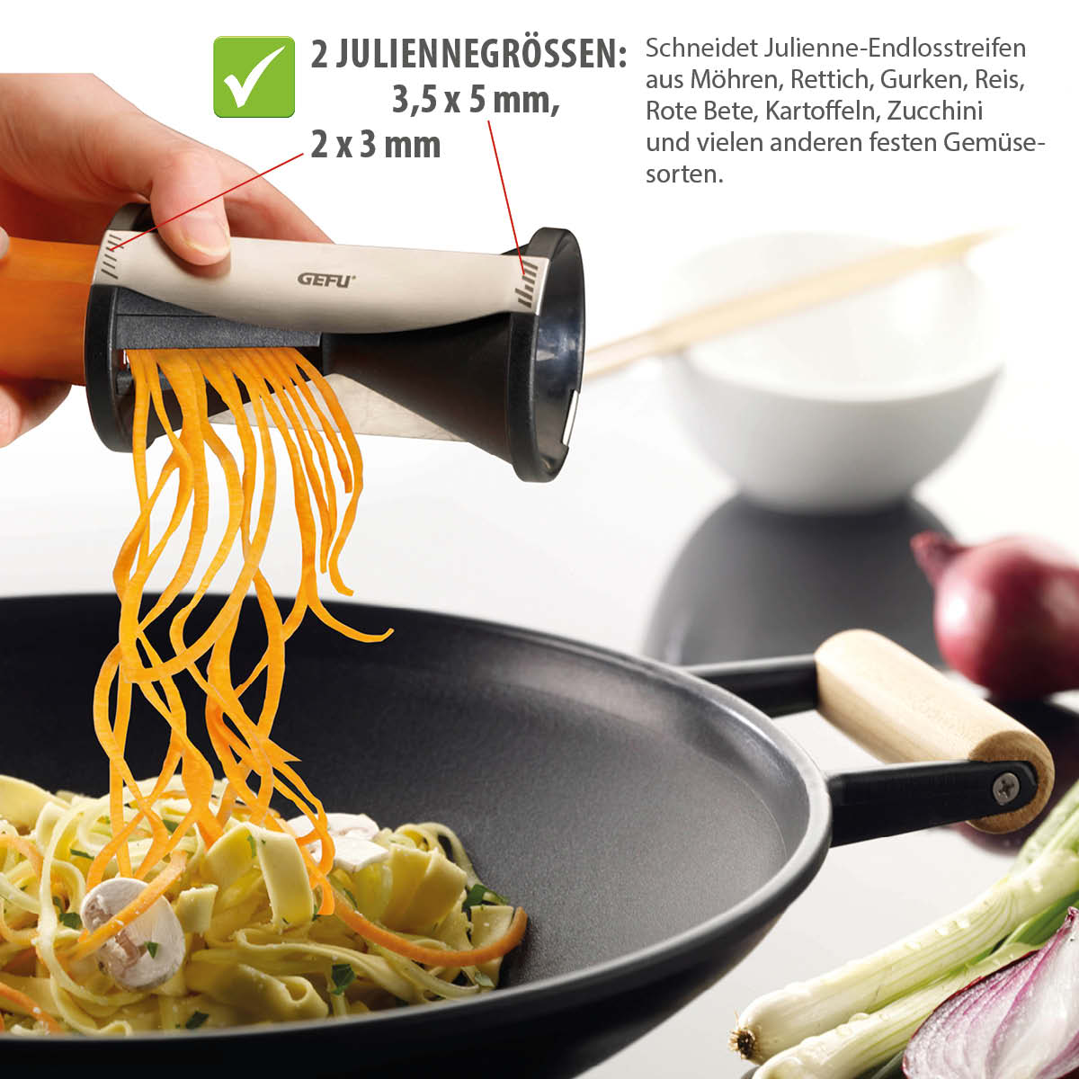 Julienneschneider für verschiedene Gemüsegrößen in zwei Schnittstärken Julienneschneider schneidet Möhren über einer Pfanne in dünne Streifen