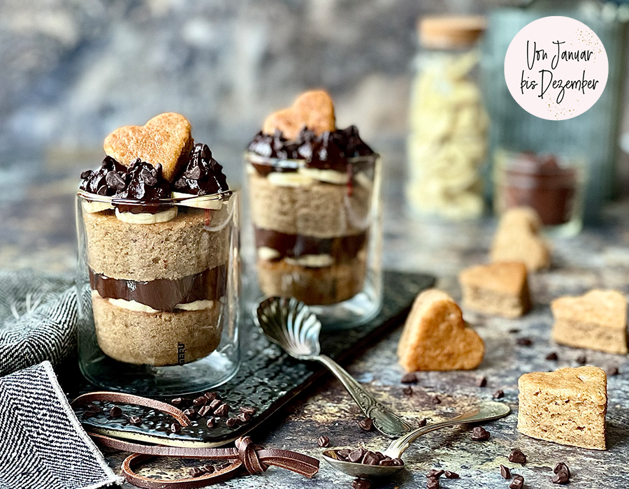 Veganes Schichtdessert „Bananas in a glass Dekoratives Dessert im Glas mit schokoladigen Schichten und herzförmiger Keksdekoration