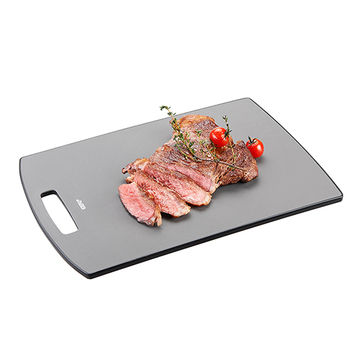 Hochwertiges Schneidebrett mit geschnittenem Steak und Tomaten Schneidebrett mit geschnittenem Steak, grüner Garnitur und zwei Kirschtomaten