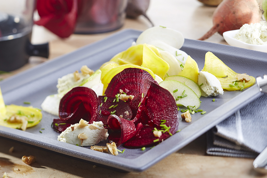 Bete Salat mit Wasabi-Frischkäse-Nocken und Nuss-Ingwer-Dressing Ein Teller mit einem Rote-Beete-Salat, dekoriert mit Ziegenkäse, Walnüssen und frischen Kräutern.