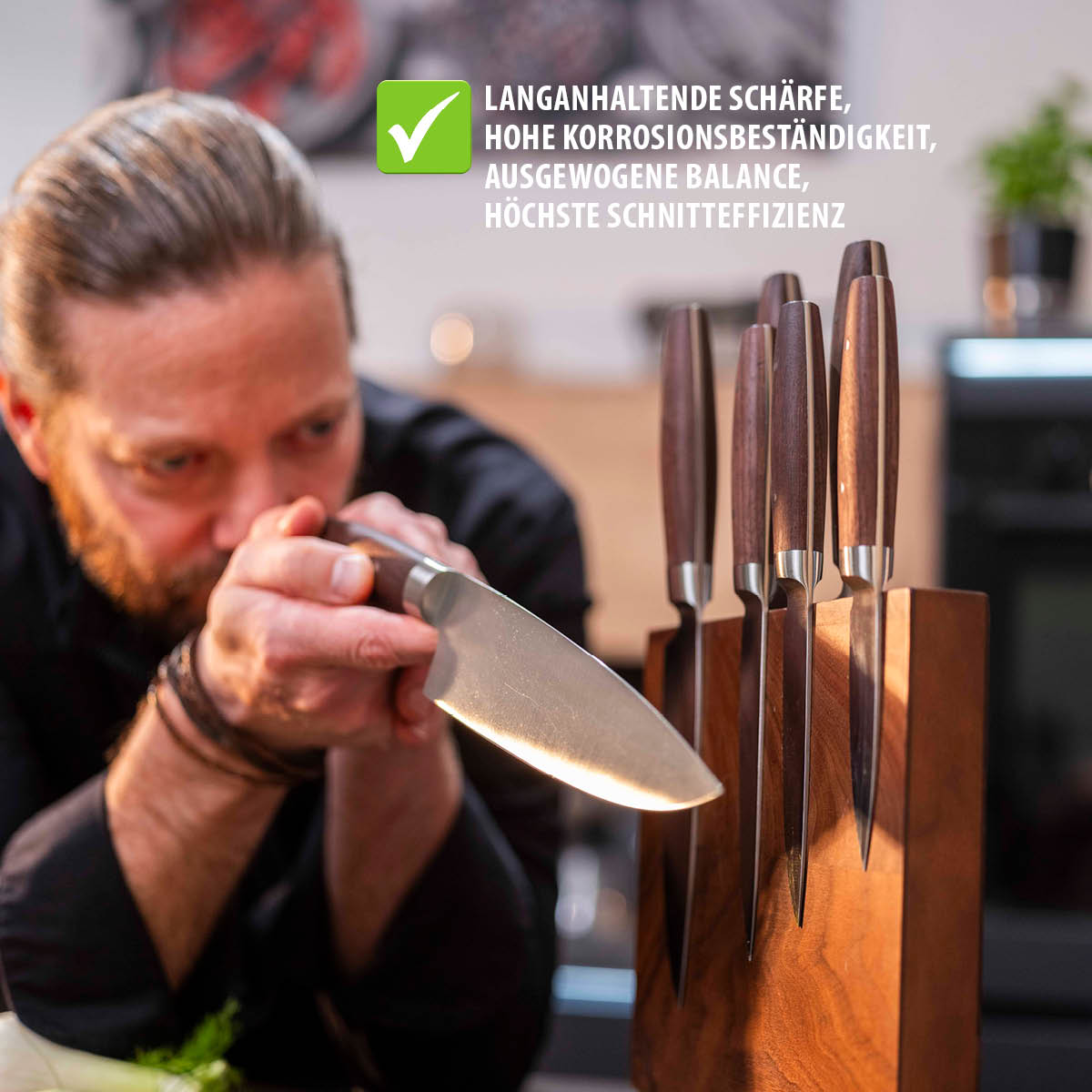 Hochwertiges Messerset mit langanhaltender Schärfe und Korrosionsbeständigkeit Ein Mann schärft ein Messer aus einem eleganten Messerset mit hölzernem Messerblock in einer modernen Küche.