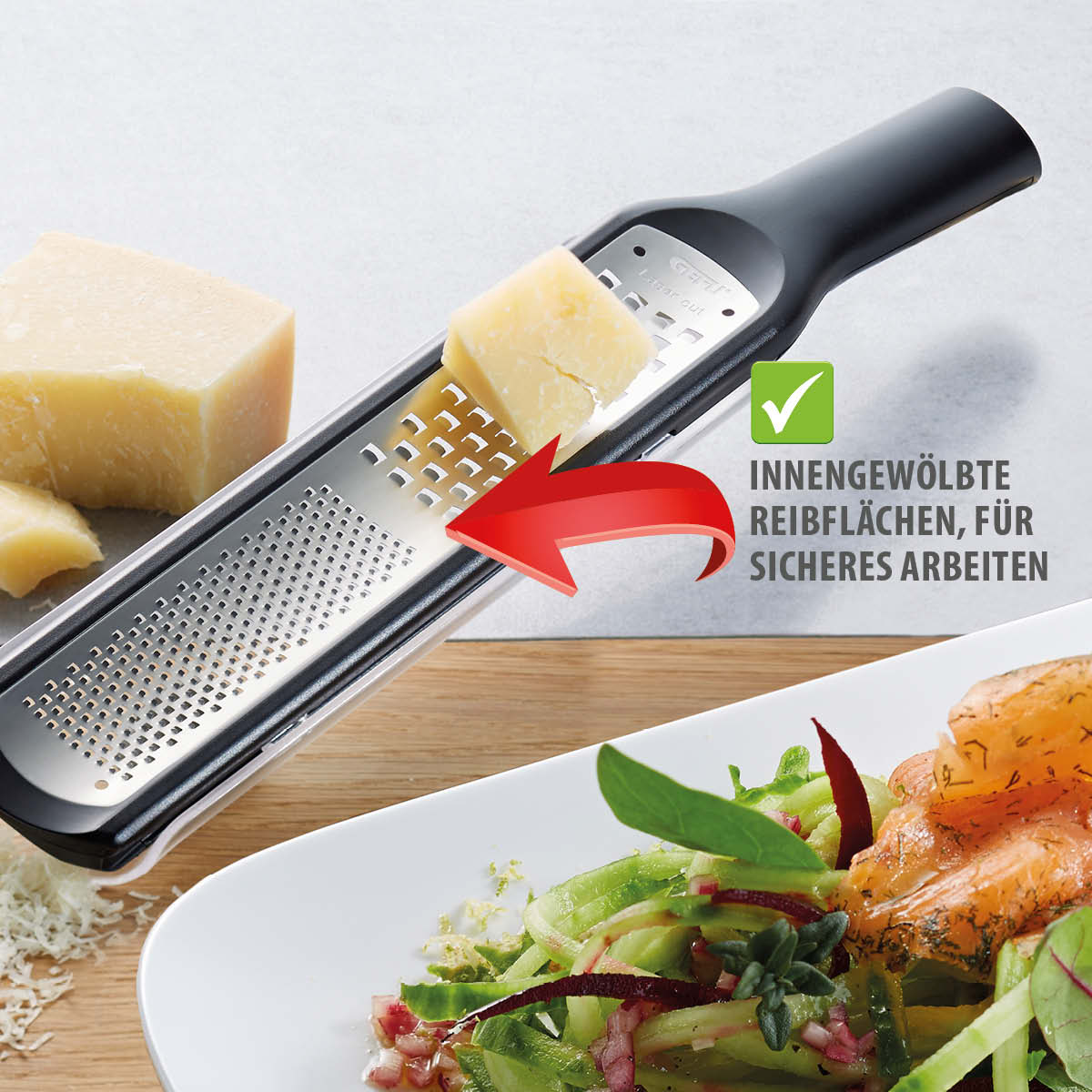 Käse wird mit einer Küchenreibe mit gewölbten Reibflächen gerieben, um die Zubereitung von Gerichten zu erleichtern.
