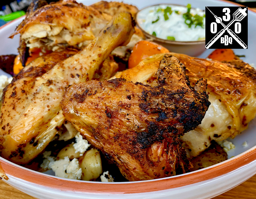 Beer can Chicken Nahaufnahme von gegrilltem Hähnchen auf einem Teller mit Gemüse und einer Schale Dip