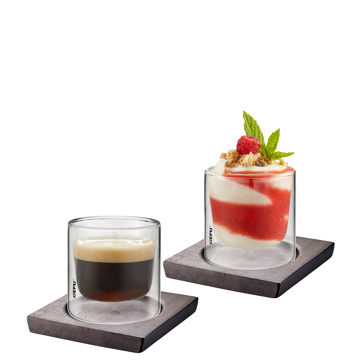 Doppelwandige Gläser mit Espresso und Dessert auf Untersetzer Zwei doppelwandige Gläser auf quadratischen Untersetzern, eines mit Espresso und das andere mit einem Dessert aus Joghurt, Erdbeersauce und Granola, dekoriert mit einer Himbeere und Minzblättern.