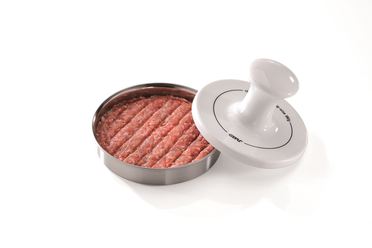 Praktische Hamburgerpresse mit frischem Hackfleisch befüllt Eine Hamburgerpresse aus Metall und Kunststoff, gefüllt mit frischem Hackfleisch, liegt auf einem weißen Hintergrund. Ideal zur Zubereitung gleichmäßiger Burger-Patties.
