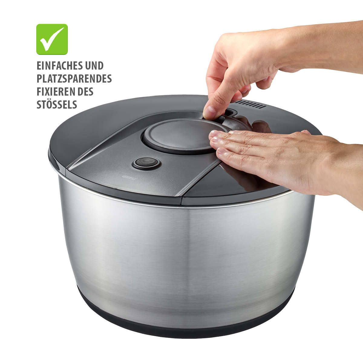 Moderner Küchenhelfer mit einfachem Stößelmechanismus Hände fixieren den Stößel eines modernen Küchengeräts in Edelstahloptik mit platzsparendem Design.