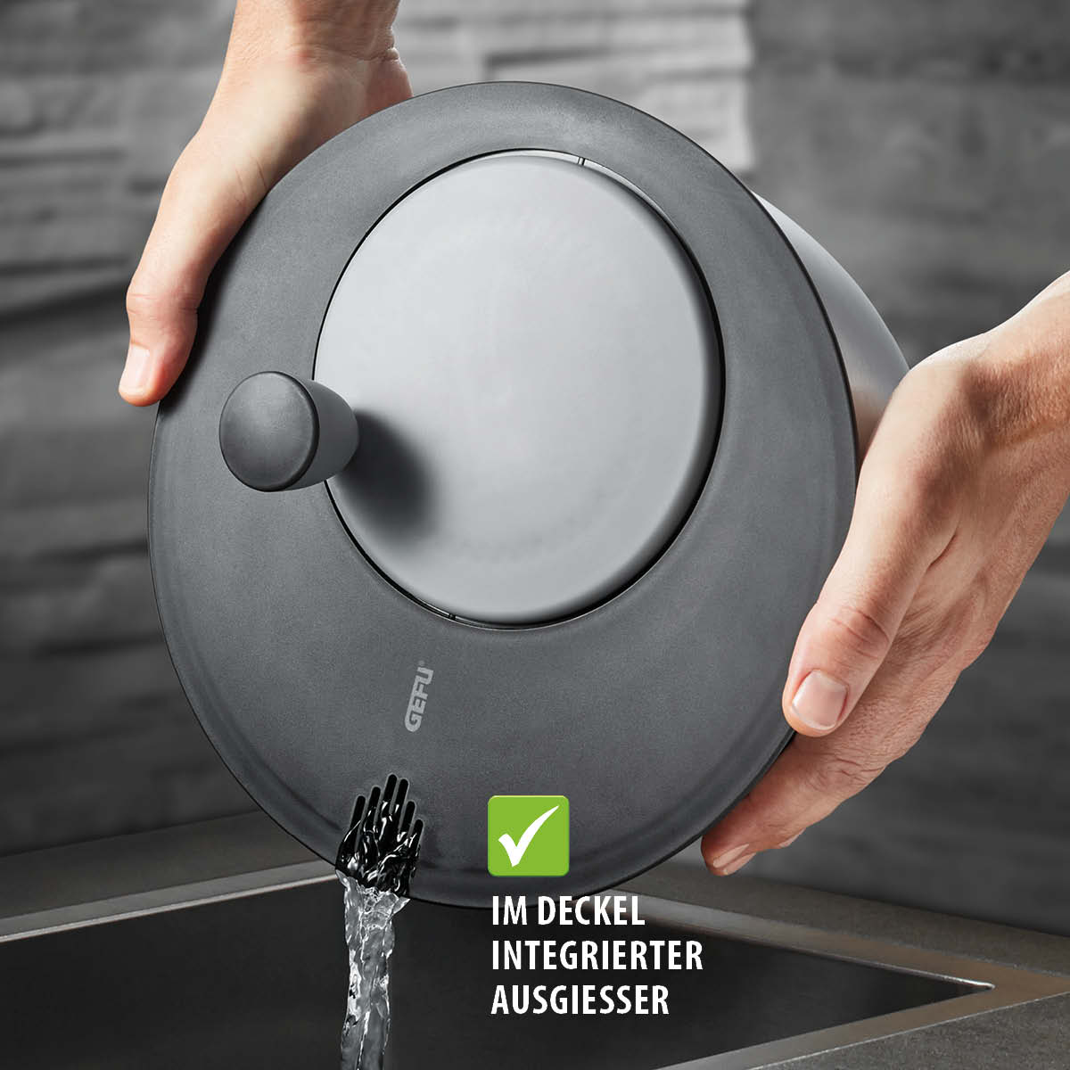 Topfdeckel mit integriertem Ausgießer - Praktisches Design für einfaches Abgießen Hände halten einen Topfdeckel mit integriertem Ausgießer über einer Spüle, Wasser fließt heraus