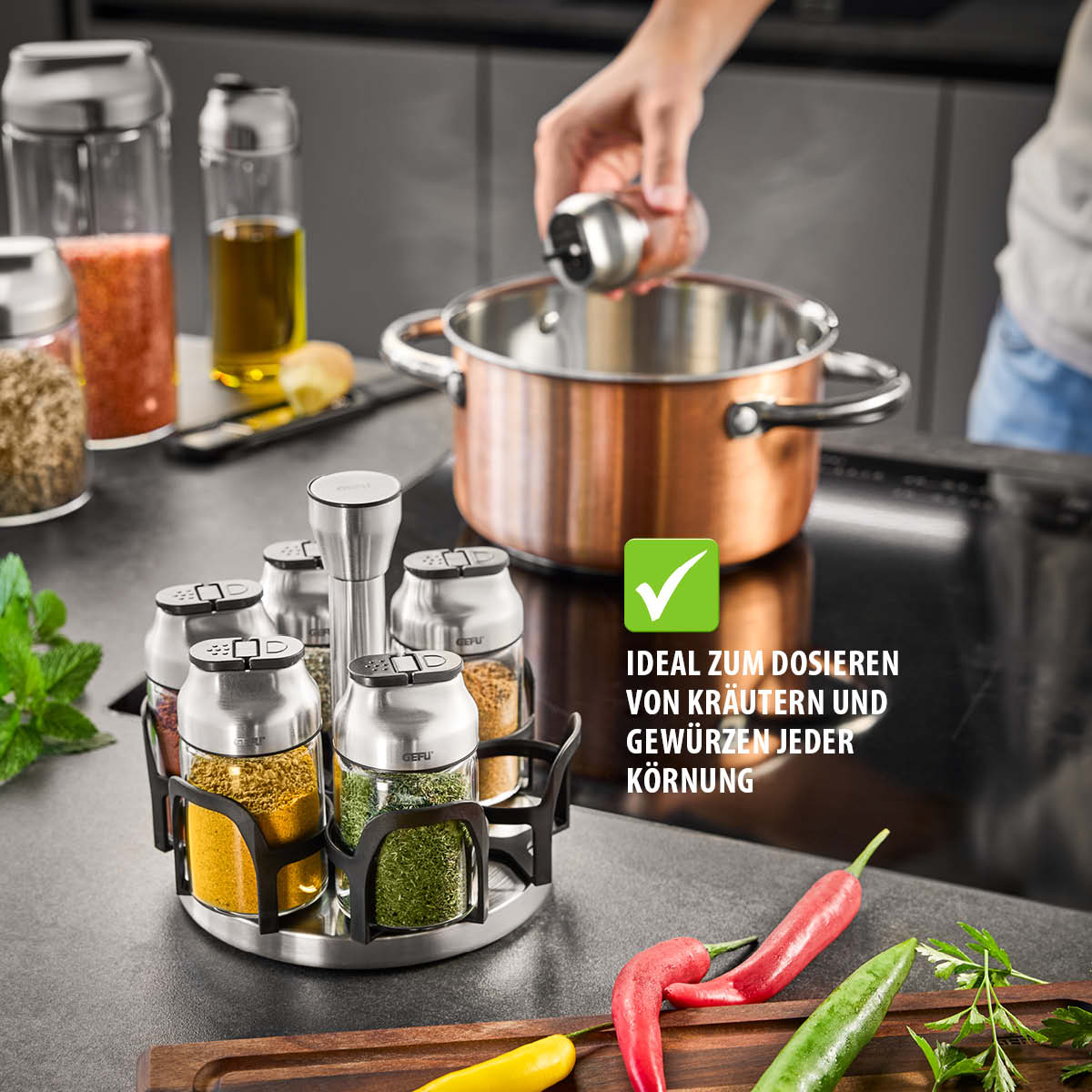 Gewürzkarussell mit streueinfachen Behältern und Kupferkochtopf in moderner Küche Ein Gewürzkarussell mit verschiedenen Gewürzen in einem modernen Küchenambiente neben einem Kupferkochtopf. Perfekt zum Dosieren von Kräutern und Gewürzen jeder Körnung.