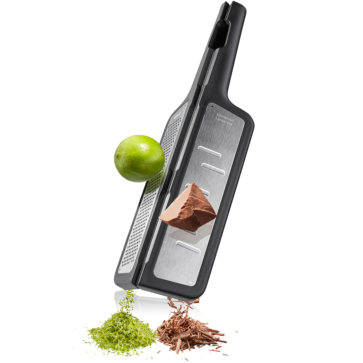 Küchenreibe aus Edelstahl mit Limette und Schokoladenstück, daneben geriebene Limettenschalen und Schokoladenraspeln