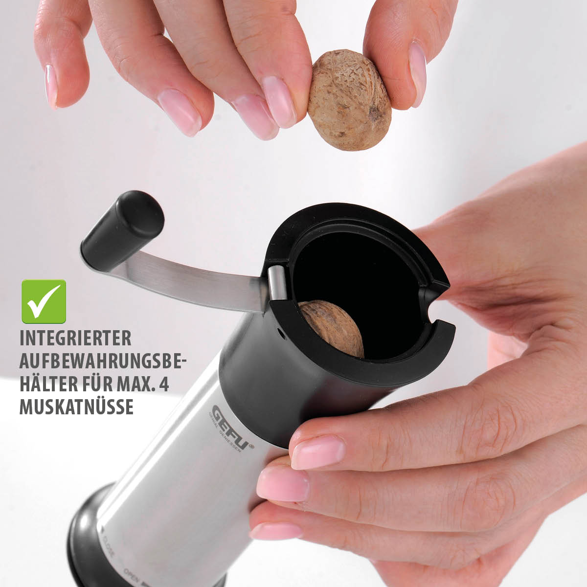 Muskatmühle mit integriertem Aufbewahrungsbehälter für bis zu 4 Muskatnüsse Eine Hand hält eine Muskatnuss über eine Muskatmühle mit integriertem Aufbewahrungsbehälter für maximal 4 Muskatnüsse.