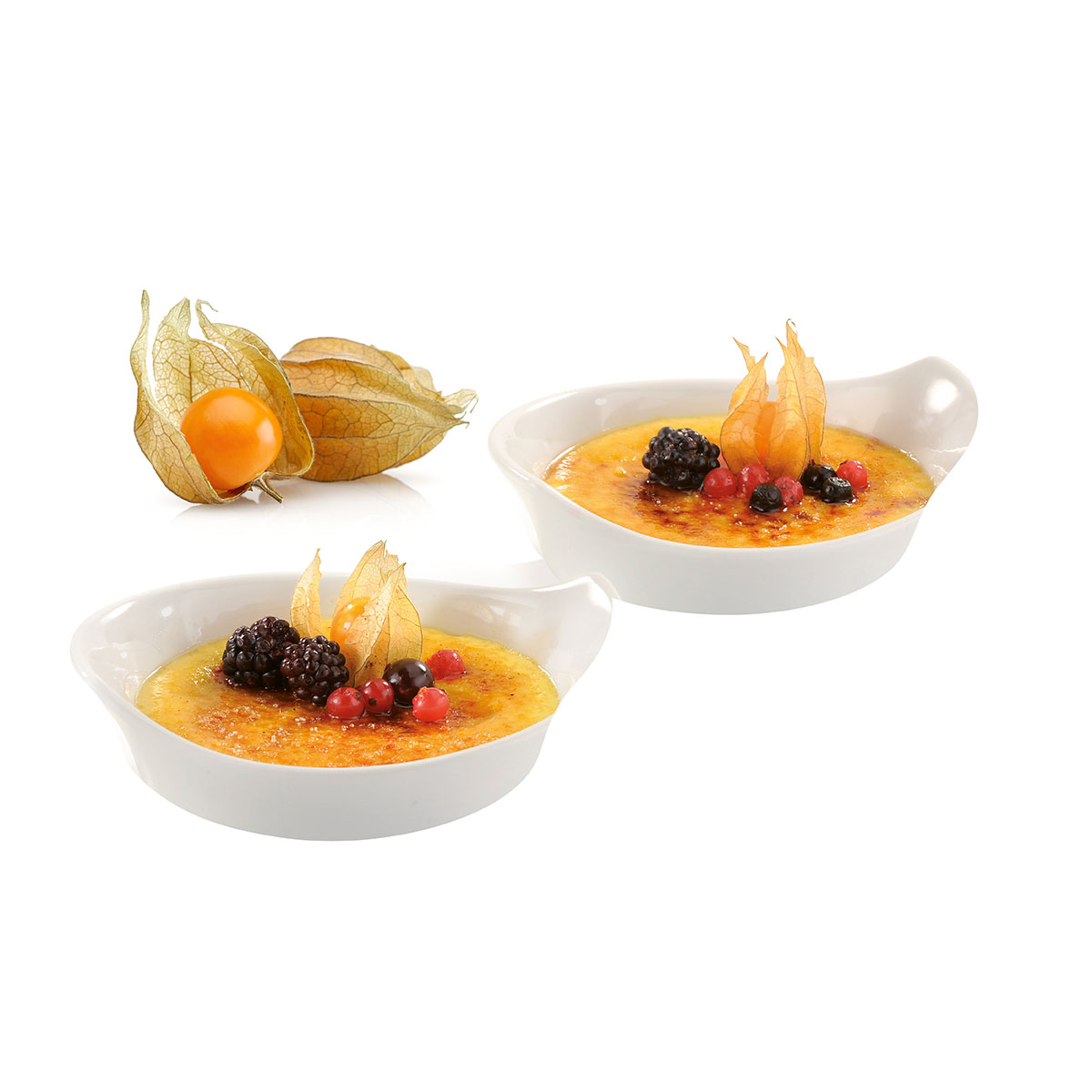 Zwei Schälchen Crème Brûlée, dekoriert mit Brombeeren, Johannisbeeren und Physalis, auf weißem Hintergrund