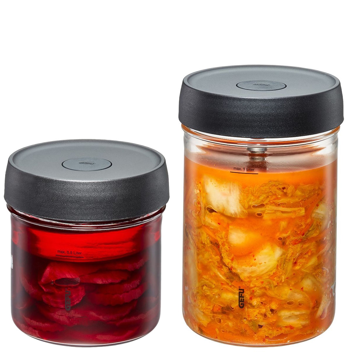 Zwei Vorratsgläser mit Deckel, gefüllt mit fermentierten Lebensmitteln Vorratsgläser mit schwarzem Deckel, eines mit rotem Inhalt, das andere mit orangefarbenem Gemüse