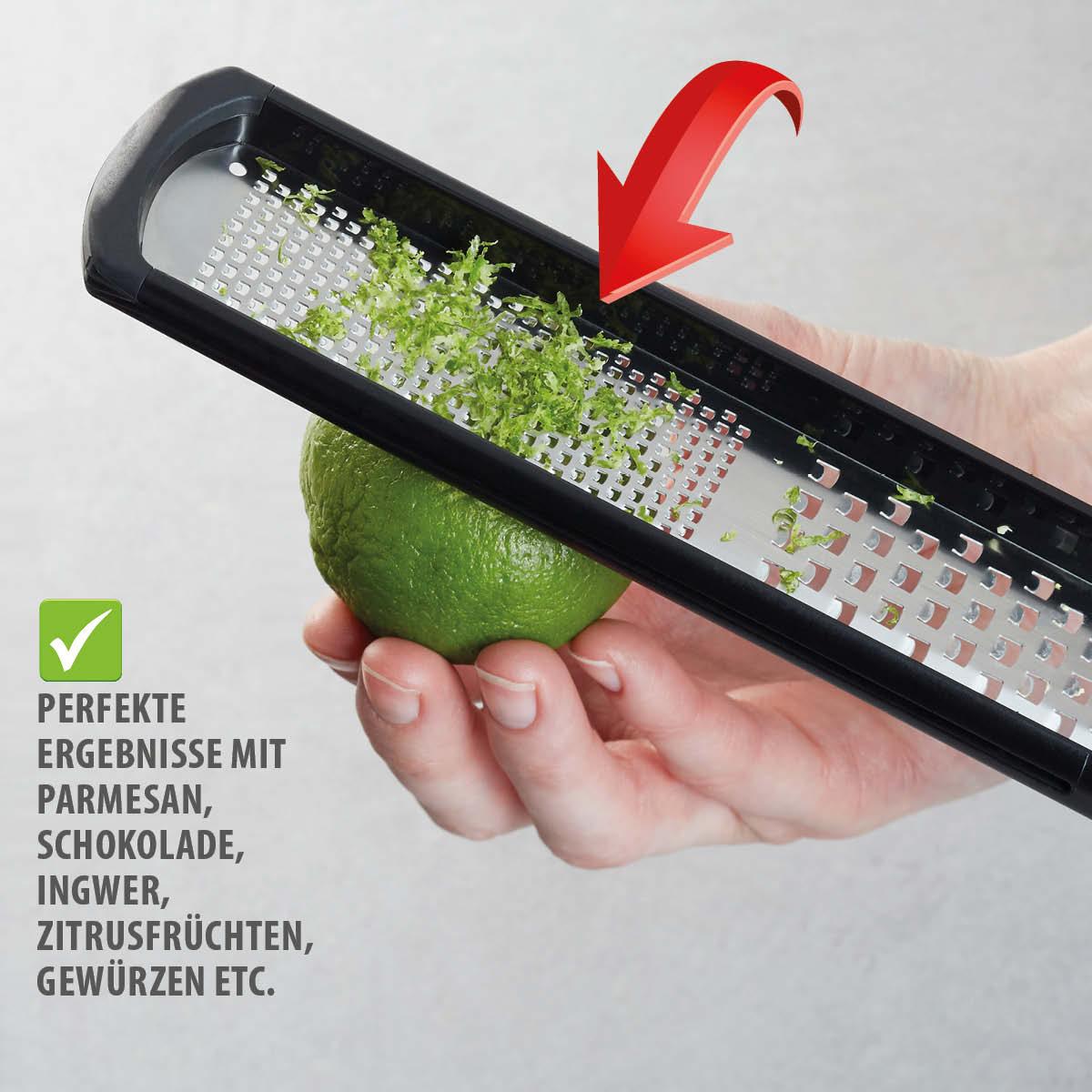 Hand hält eine grüne Limette unter einer schwarzen Feinreibe, perfekt zum Reiben von Parmesan, Schokolade, Ingwer, Zitrusfrüchten und Gewürzen.