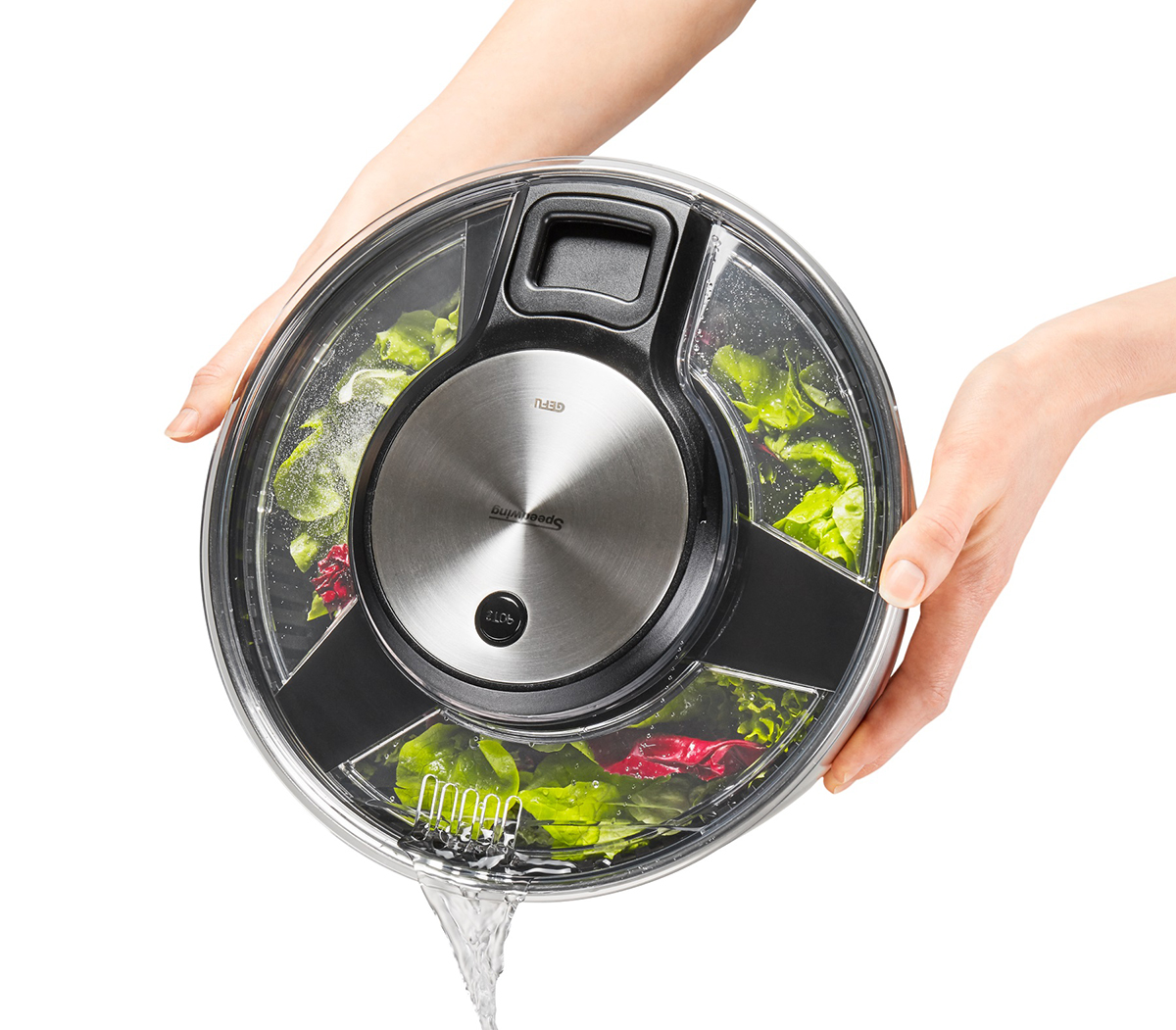 Effiziente Salatschleuder für schnelle Trocknung Hände halten eine Salatschleuder mit abfließendem Wasser und frischem Salat