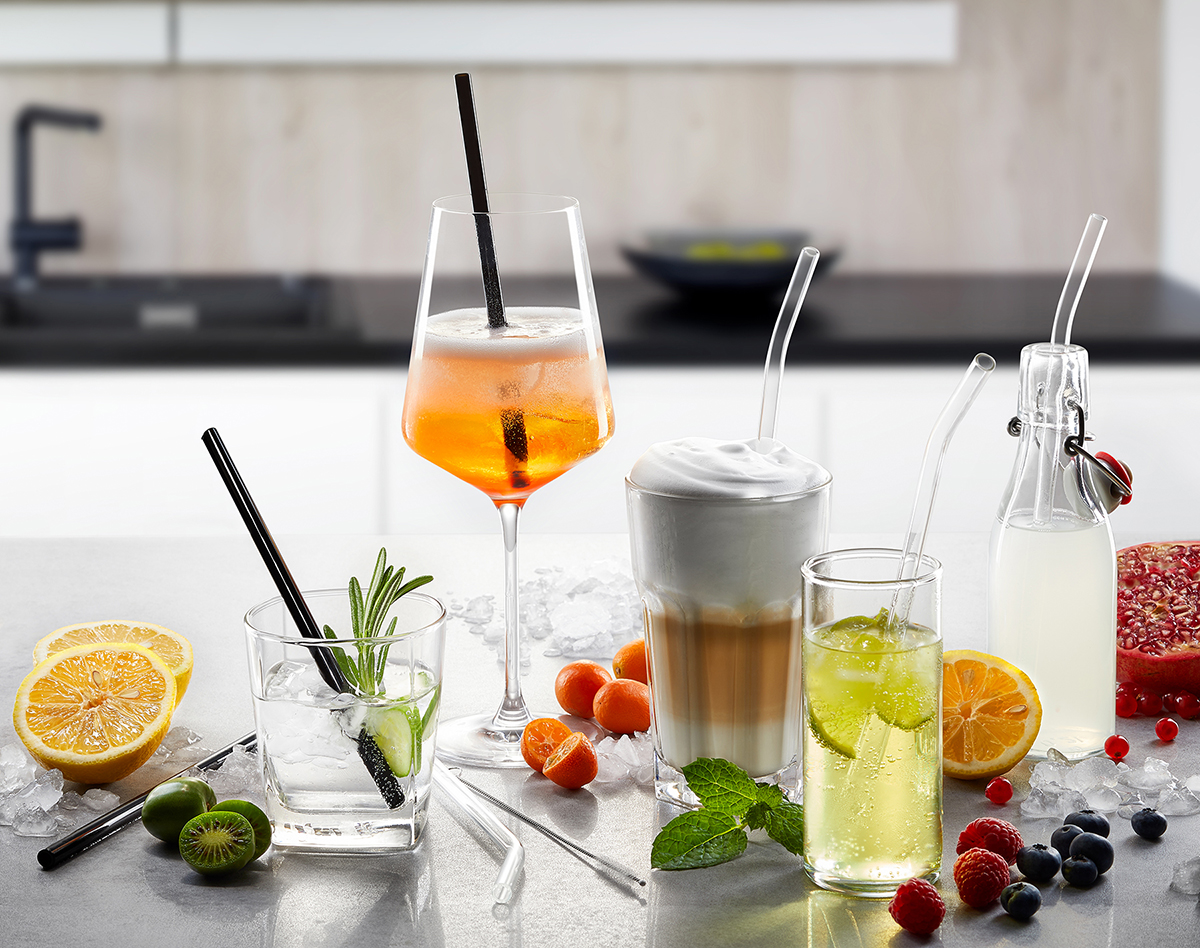 Ein Arrangement von Getränken wie Spritz, Latte Macchiato, Limonade und Cocktails mit Früchten und Eis in einer modernen Küche