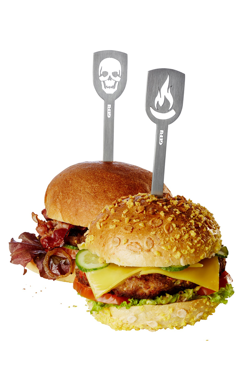 Zwei köstliche Burger mit Edelstahl-Steckern - GEFU Zwei reich belegte Burger mit Edelstahl-Steckern von GEFU, einer mit Totenkopf und einer mit Flammen. Perfekt für Grillliebhaber.