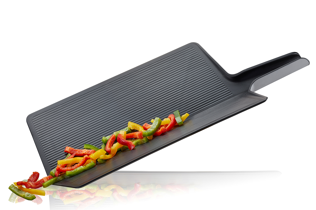 Schneidbrett mit Griff und bunten Paprikastreifen Schwarzes Schneidbrett mit Griff, darauf liegen geschnittene rote, gelbe und grüne Paprikastreifen