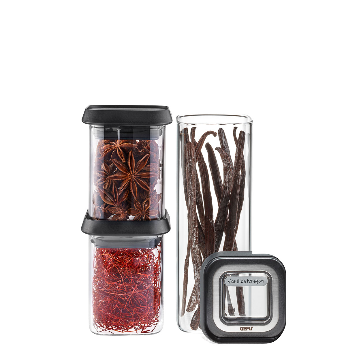 Gewürzgläser-Set mit Vanillestangen, Sternanis und Safranfäden Ein Gewürzgläser-Set bestehend aus Gläsern mit Vanillestangen, Sternanis und Safranfäden, präsentiert auf einer weißen Fläche.