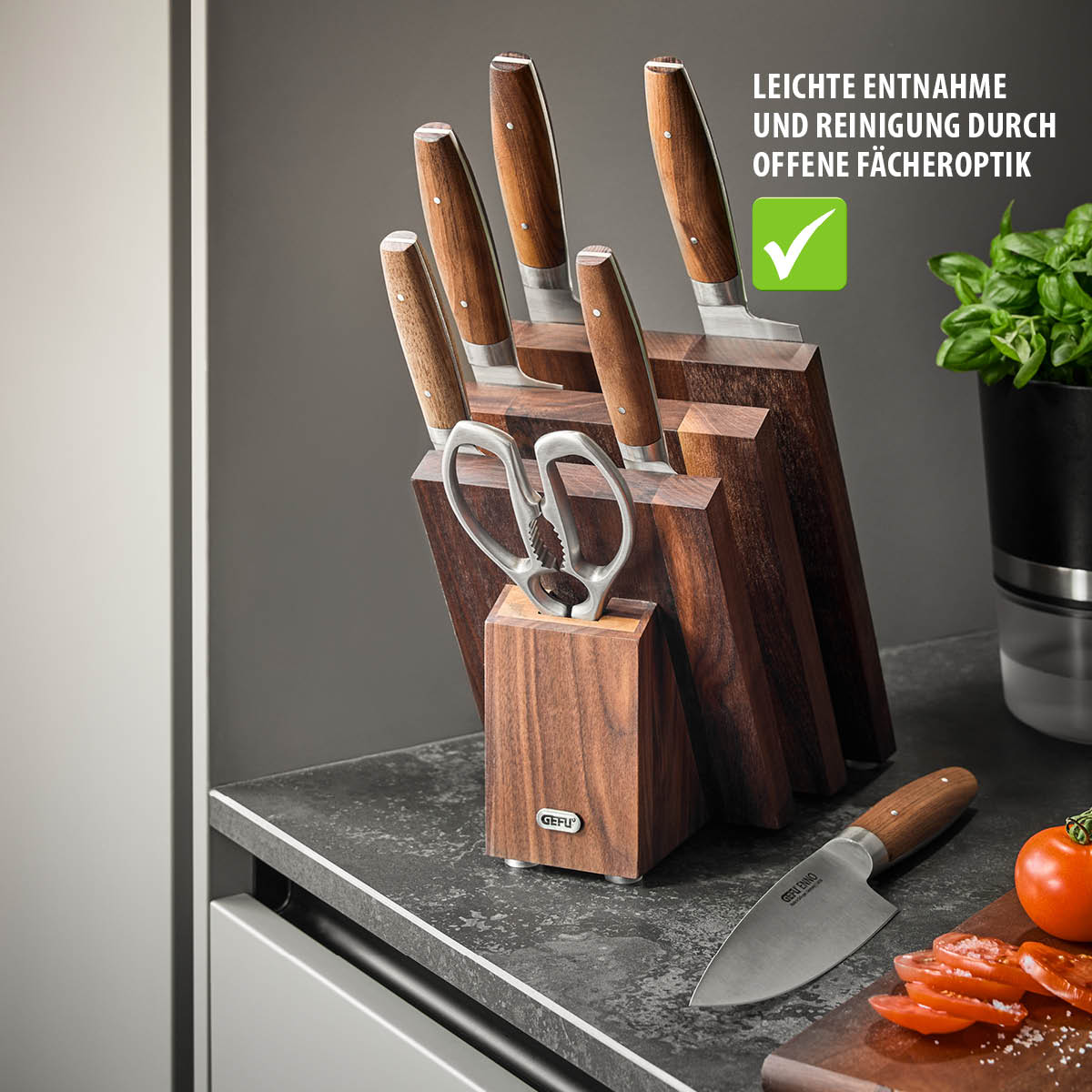 Messerblock-Set mit Holzgriffen, Schere und Küchenmesser auf Arbeitsplatte neben Tomaten