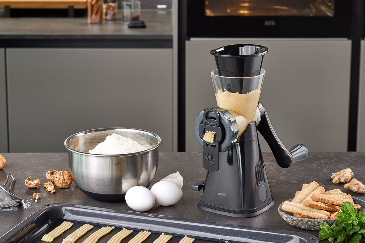 Küchenmaschine zur Teigzubereitung mit Schüssel, Eiern und Keksen