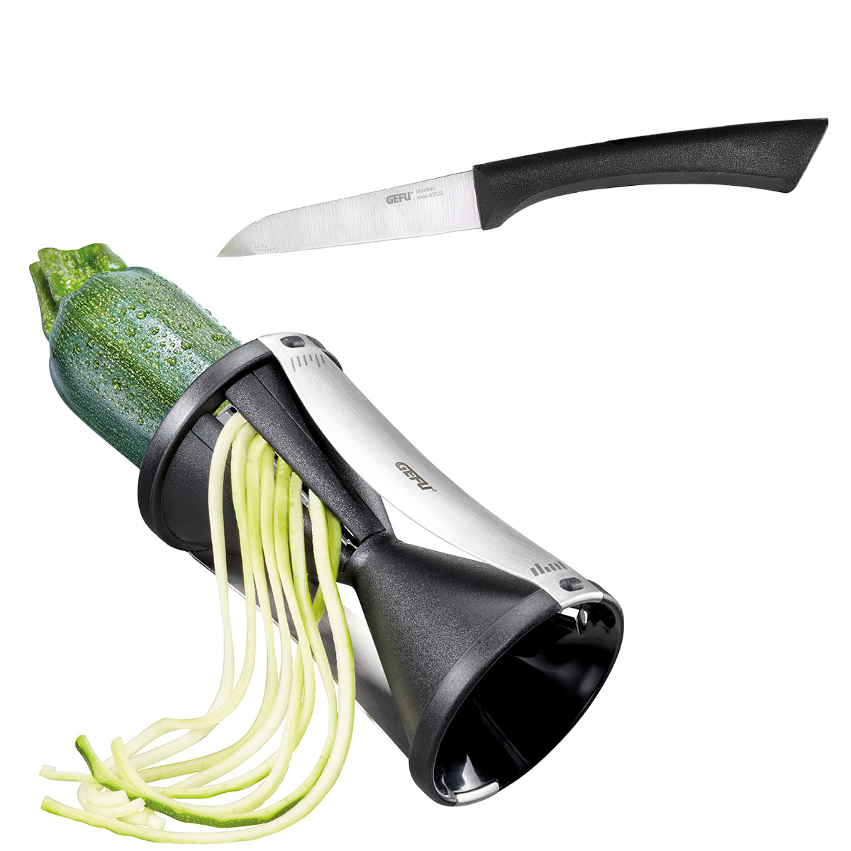 Spiralschneider für Gemüse mit Küchenmesser Spiralschneider, der eine Zucchini in Gemüsespaghetti schneidet, mit Küchenmesser