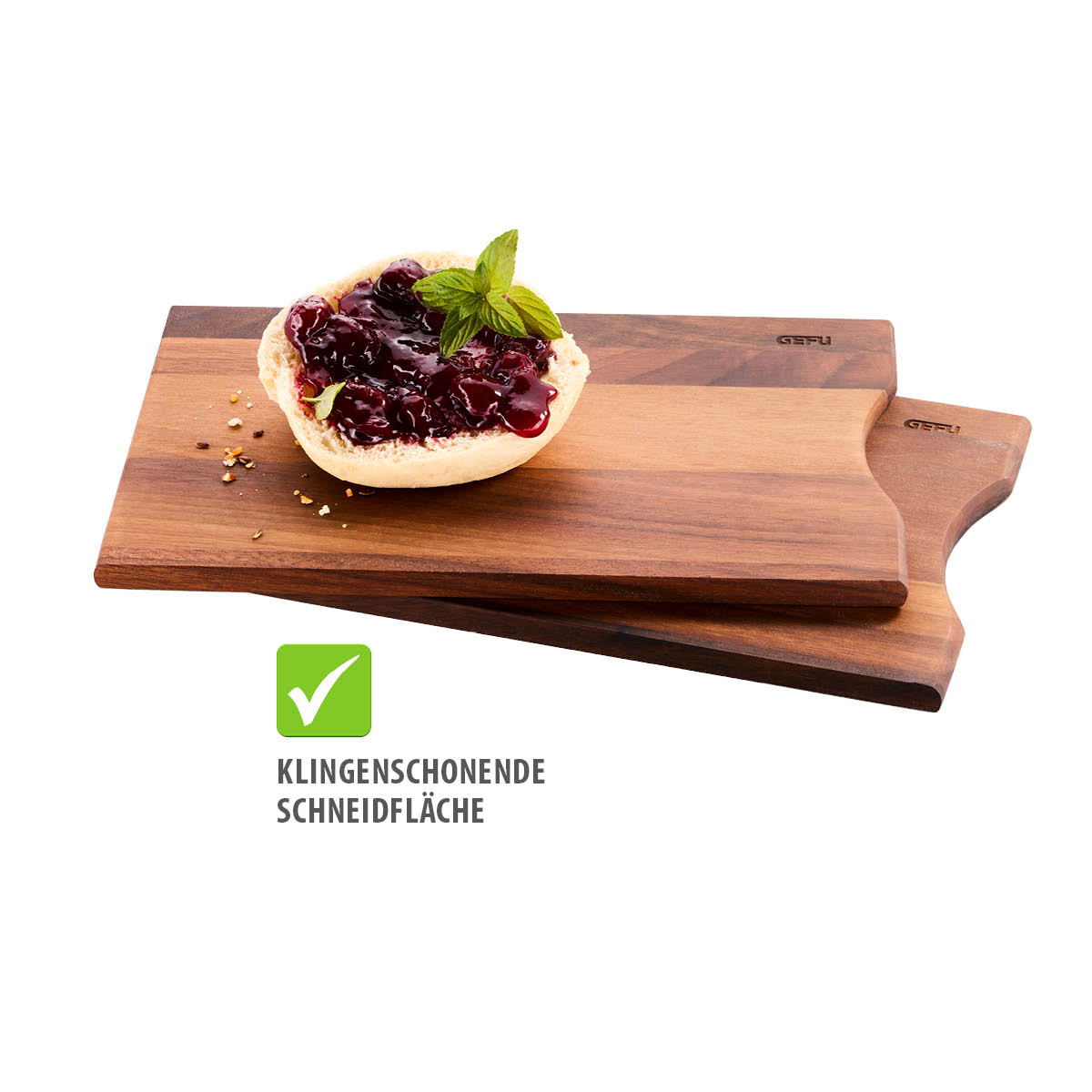 Zwei Holz-Schneidebretter, eines mit einem Brötchen, das mit roter Marmelade und einem Minzblatt garniert ist, daneben ein Symbol für klingenschonende Schneidfläche