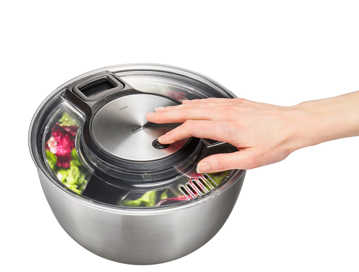 Moderne Salatschleuder aus Edelstahl mit Handbetrieb Hand bedient eine Salatschleuder aus Edelstahl, gefüllt mit Salat