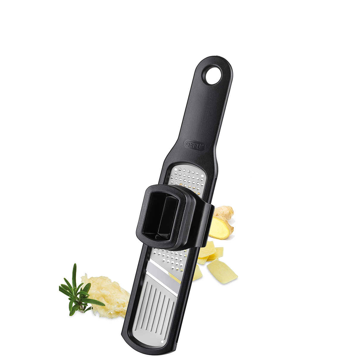 Multifunktionale Reibe mit integriertem Halter von GEFU Schwarze multifunktionale Reibe von GEFU mit integriertem Halter, geeignet zum Reiben von Ingwer und Knoblauch, vor einem weißen Hintergrund mit Ingwerscheiben und Rosmarin.