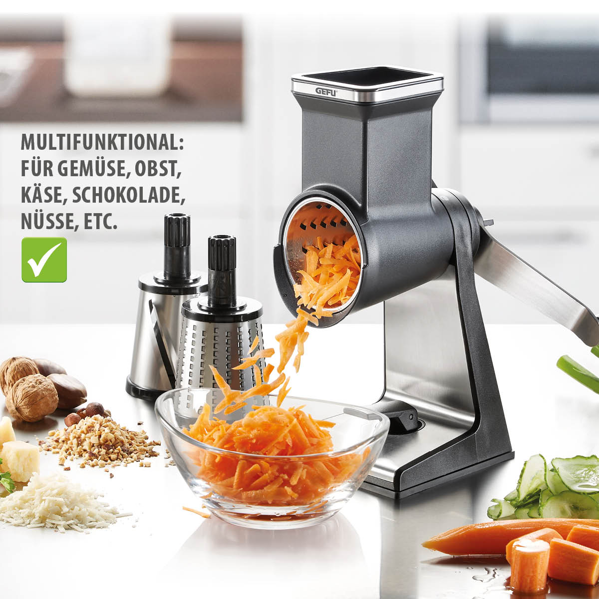 Multifunktionale Trommelreibe für Gemüse, Obst, Käse, Schokolade und Nüsse Multifunktionale Trommelreibe im Einsatz mit geraspelten Karotten und Wechselaufsätzen