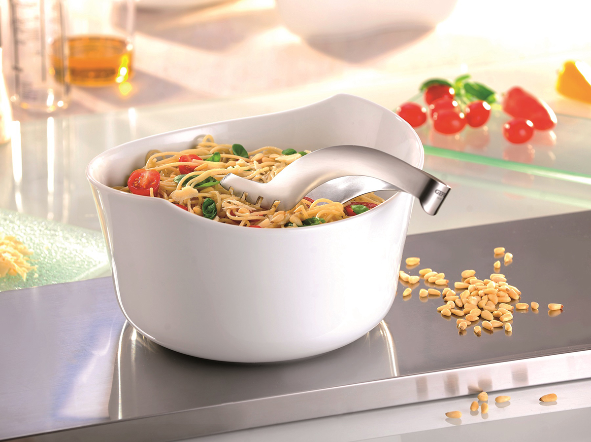 Elegante weiße Schüssel mit Spaghetti und Gemüsegarnitur Weiße Schüssel voller Spaghetti mit Tomaten und Basilikum, dekoriert mit einer Nudelkelle