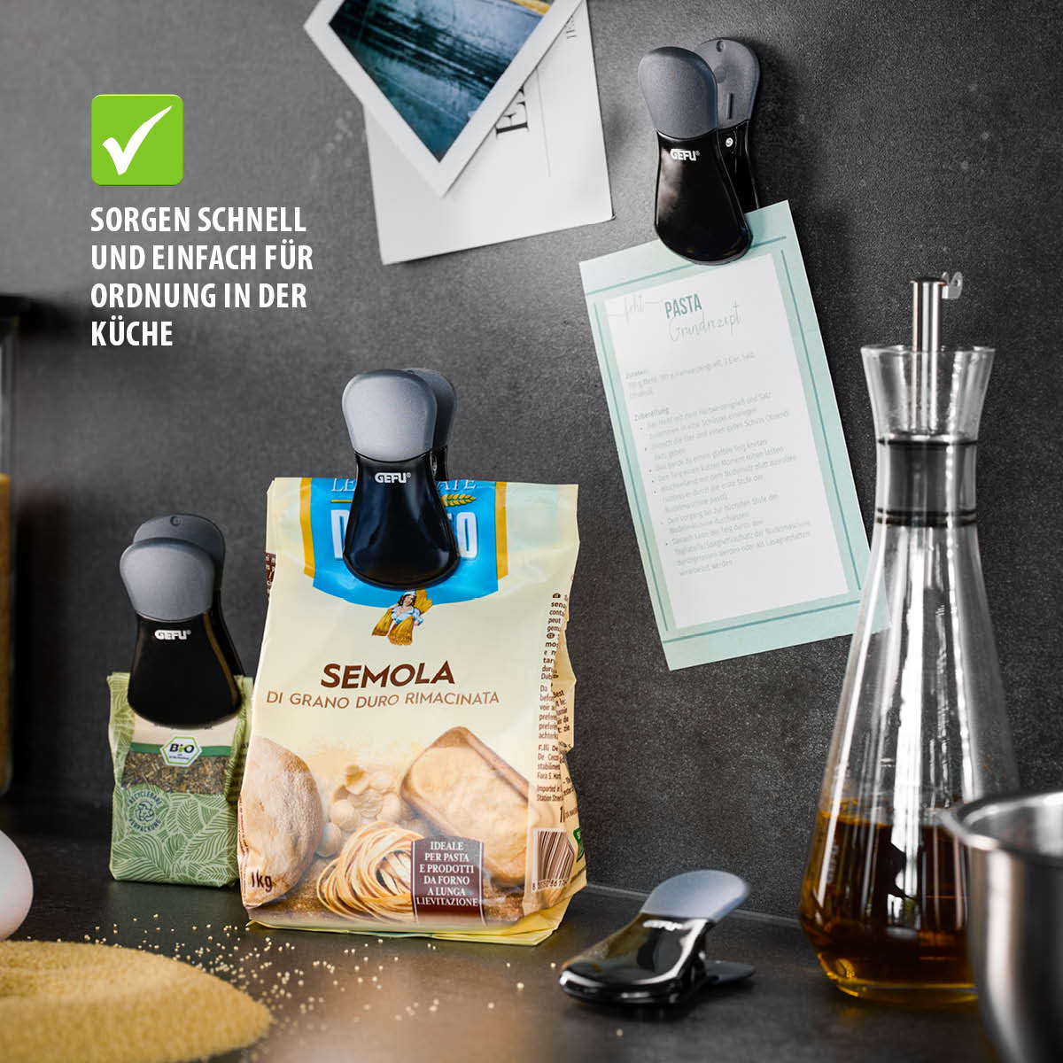 Küchenclips zur Aufbewahrung von Lebensmitteln, befestigt an einer Packung Hartweizengrieß und einem Küchenschrank
