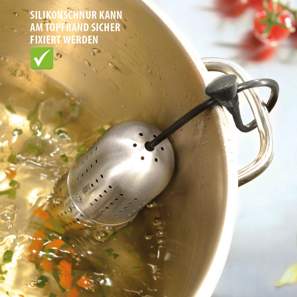 Praktischer Edelstahl-Teefilter mit Silikonschnur zur sicheren Befestigung am Topfrand Edelstahl-Teefilter in einem Kochtopf, befestigt mit einer Silikonschnur am Topfrand, zum sicheren Kochen von Brühe oder Tee