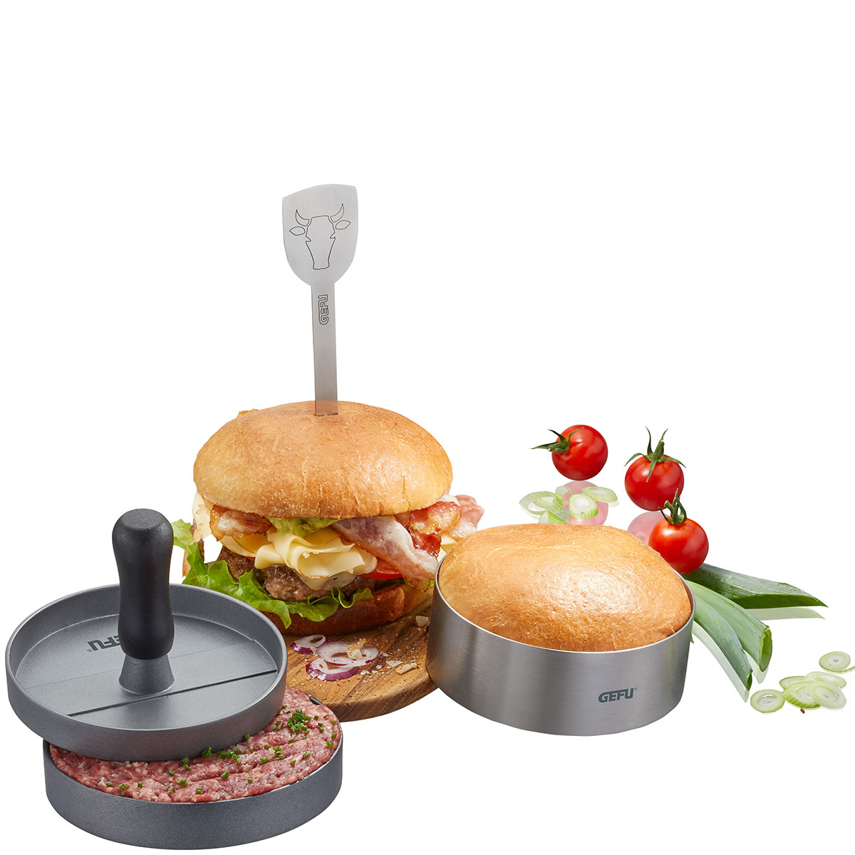 Burgerpress-Set mit Hamburgern und frischen Zutaten Burgerpress-Set, fertig zubereiteter Burger mit Speck und Käse, Rohling in Form, Cherry-Tomaten und Frühlingszwiebeln