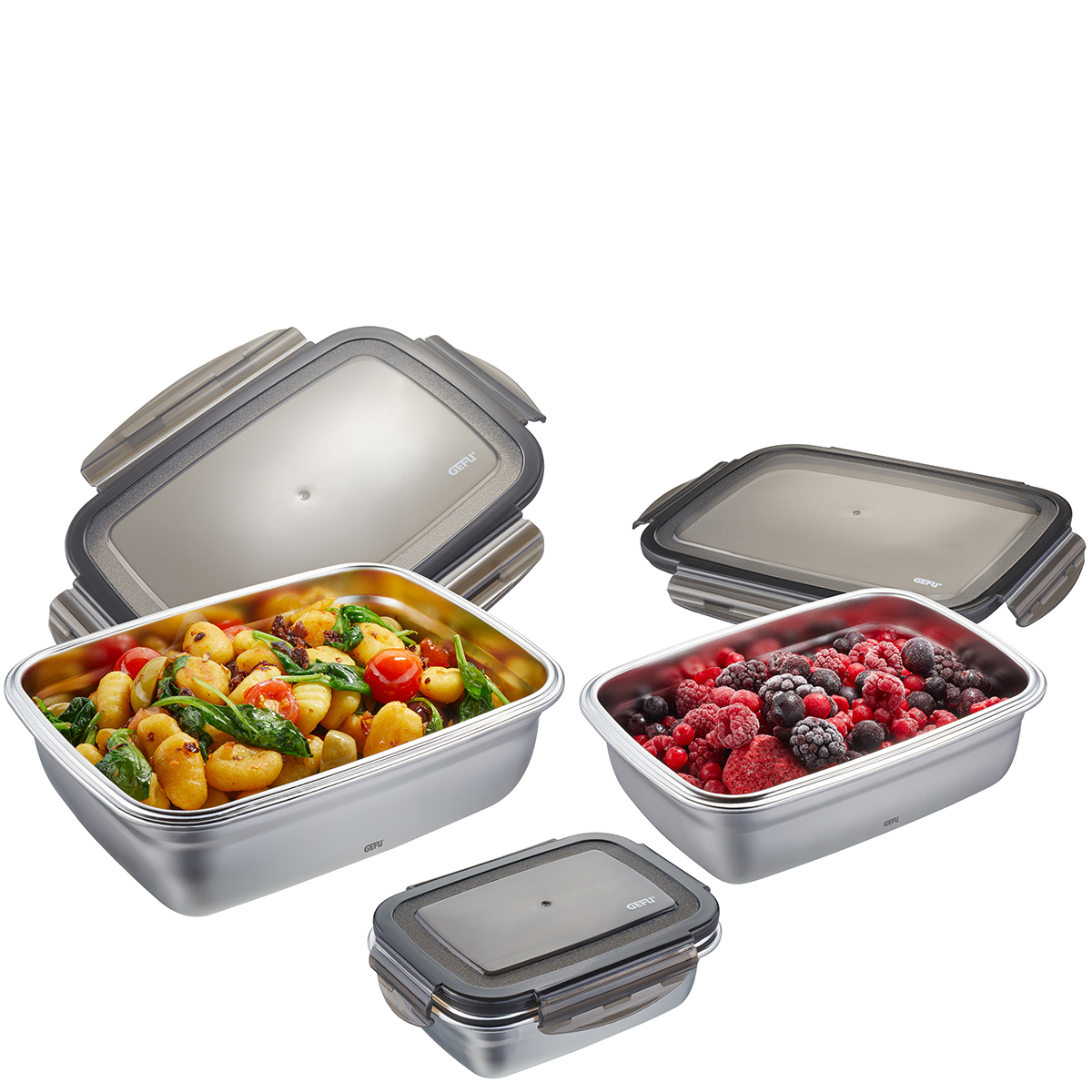 Set aus Edelstahl-Frischhaltedosen mit Lebensmitteln Verschiedene Edelstahl-Frischhaltedosen mit Pasta, Beeren und Deckeln