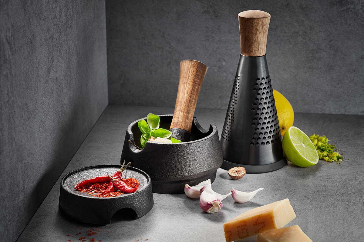 Moderner Mörser, Reibe und Frischkäse-Set für die Küche Moderner Küchen-Mörser mit hölzernem Stößel, Reibe und Zutaten wie Chilis, Knoblauch und Limetten