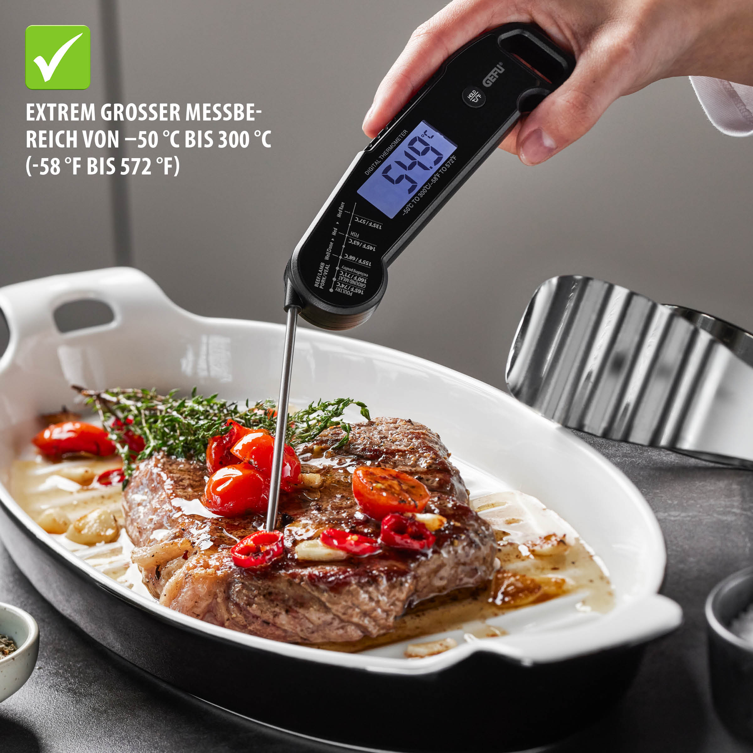 Klappbares Digital-Thermometer AUREMA von GEFU beim Messen der Kerntemperatur eines Steaks in einer Auflaufform, digitales Display und Temperaturbereich –50 °C bis 300 °C